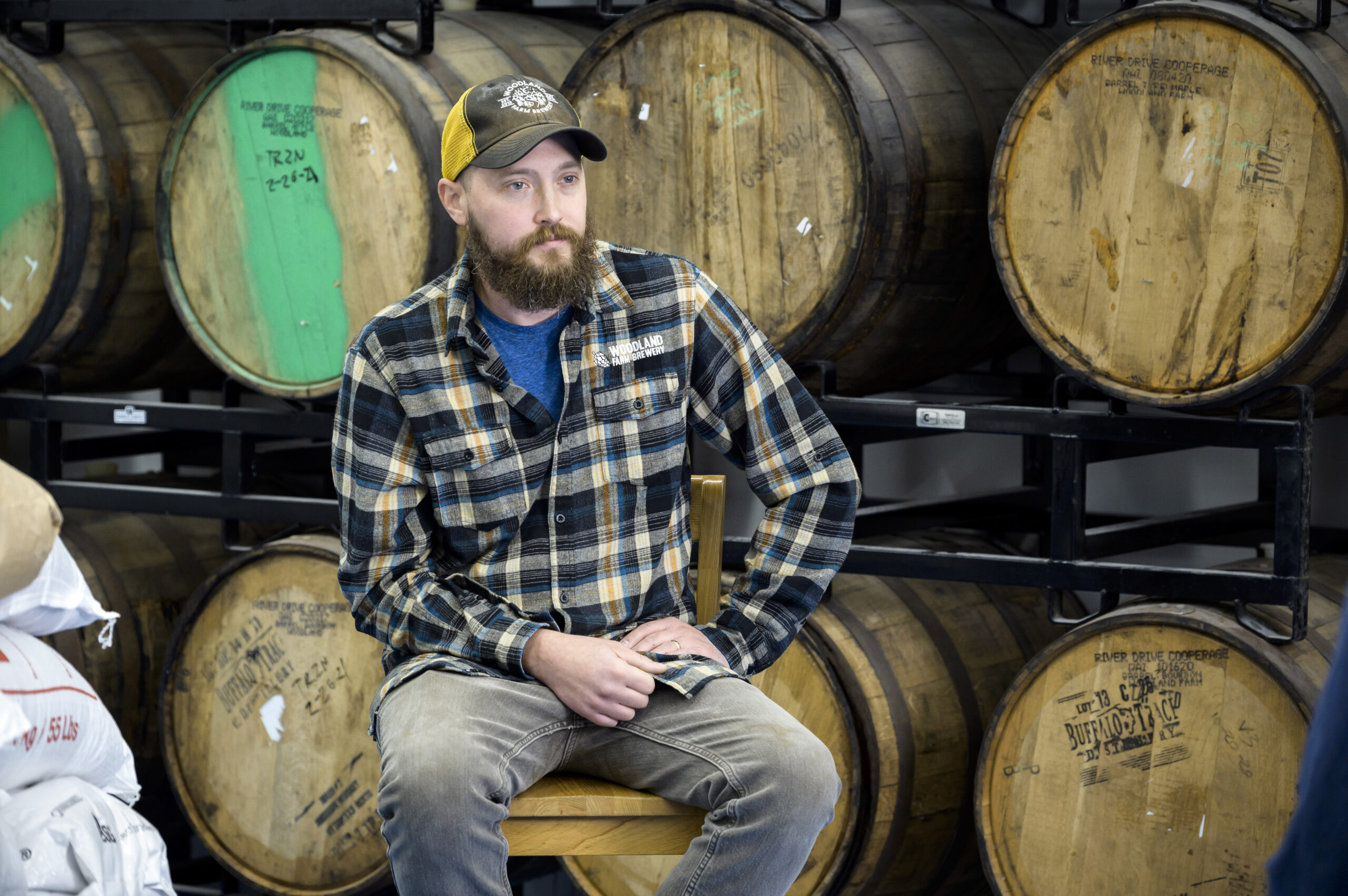 Man Sitting in front of barrels